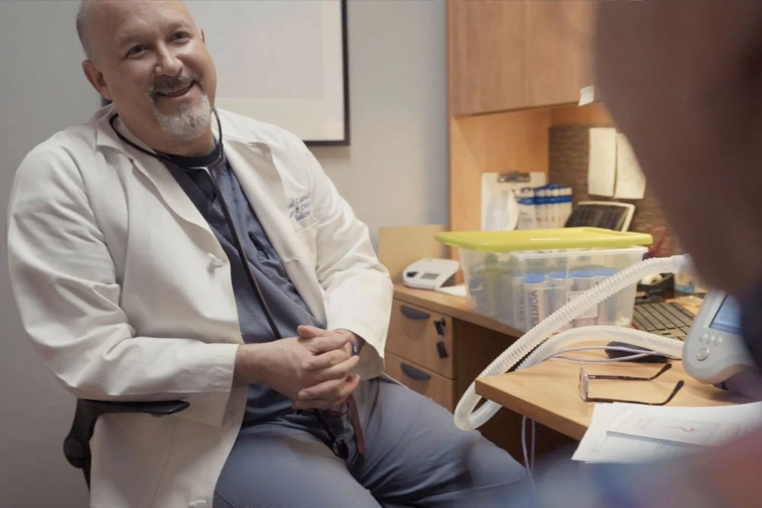 male doctor smiling at off camera patient