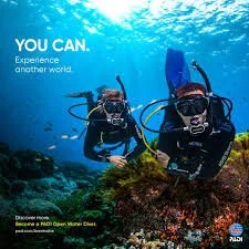 PADI Open Water student swimming underwater during certification dives in San Diego.with instructor