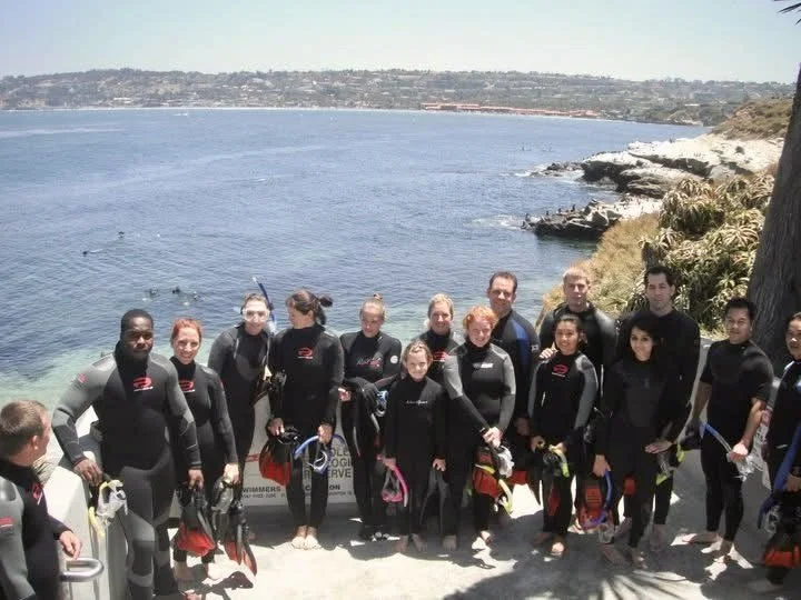 A group posing in snorkel equipment before a snorkel tour at la Jolla cove with Scuba with Justin in San Diego