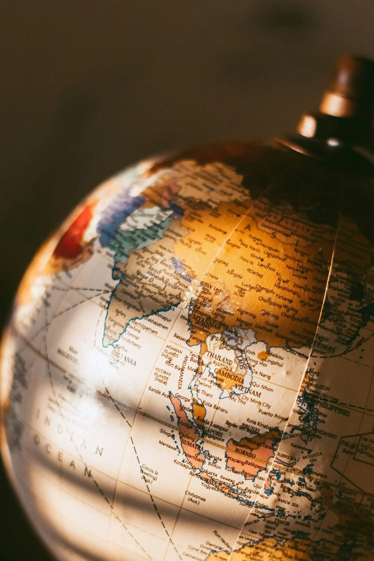 Close-up of a globe showing Southeast Asia, including countries like Thailand, Vietnam, and Malaysia, with the Indian Ocean visible.