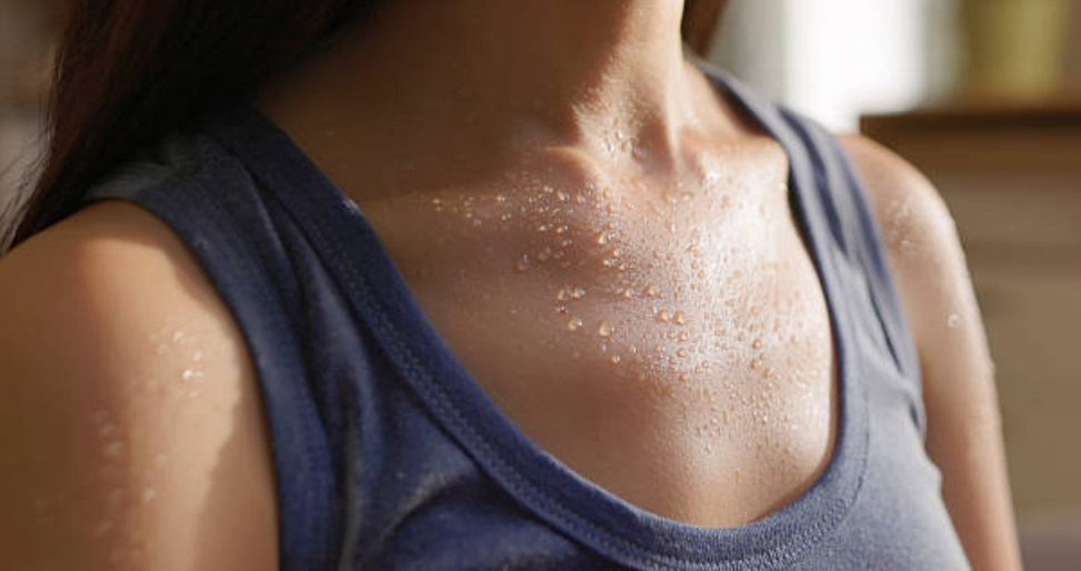 Subtle perspiration on a person’s chest and shoulders, illustrating the body’s response to controlled heat exposure.