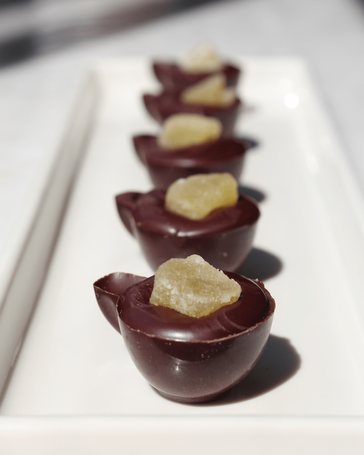Chocolate shells billed with chocolate with dried fruit piece on top.
