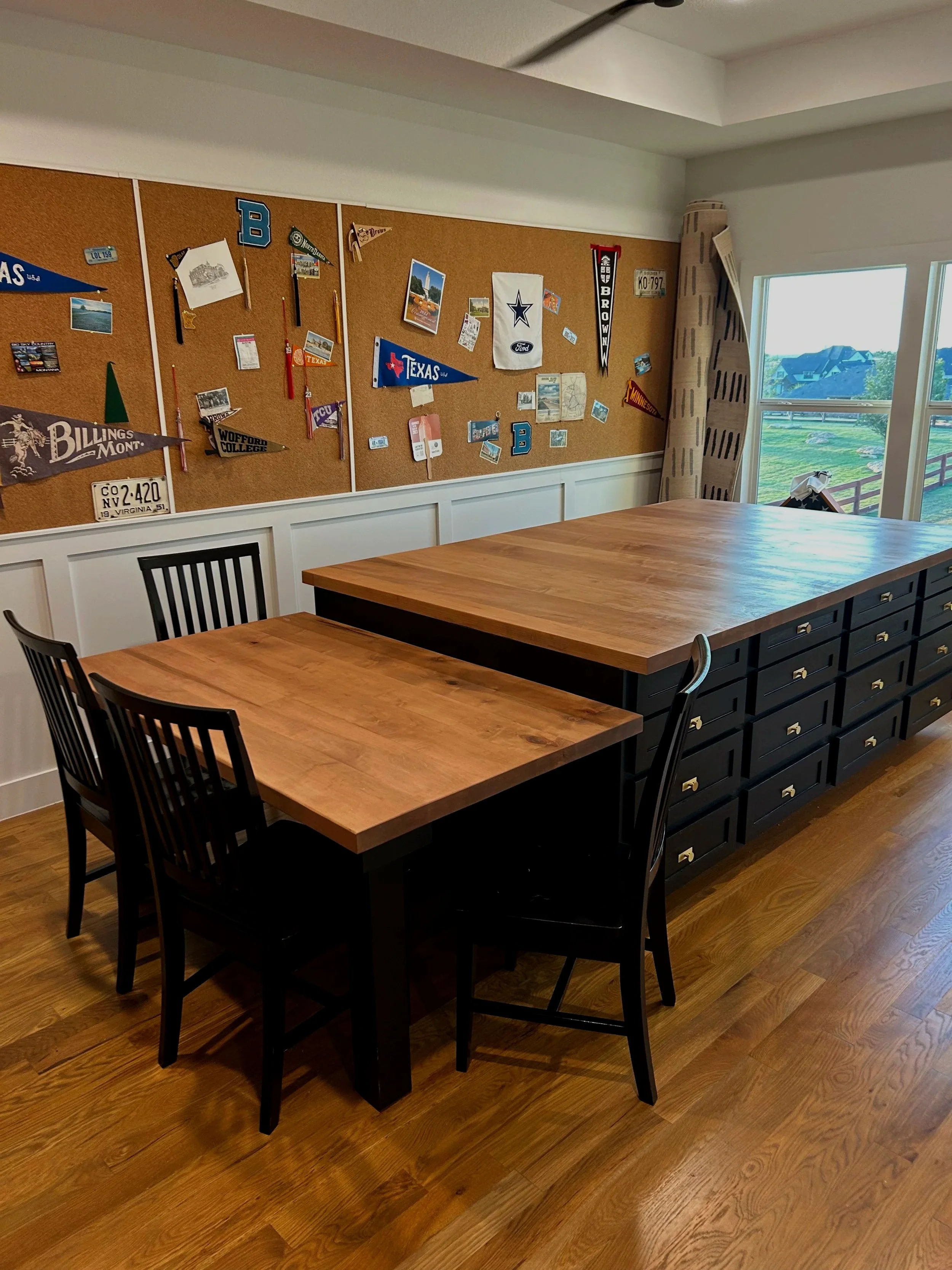 a game / craft room with a large black cabinet island, and a des/ table for crafting. Black cabinets and solid wood maple top. custom craft room.