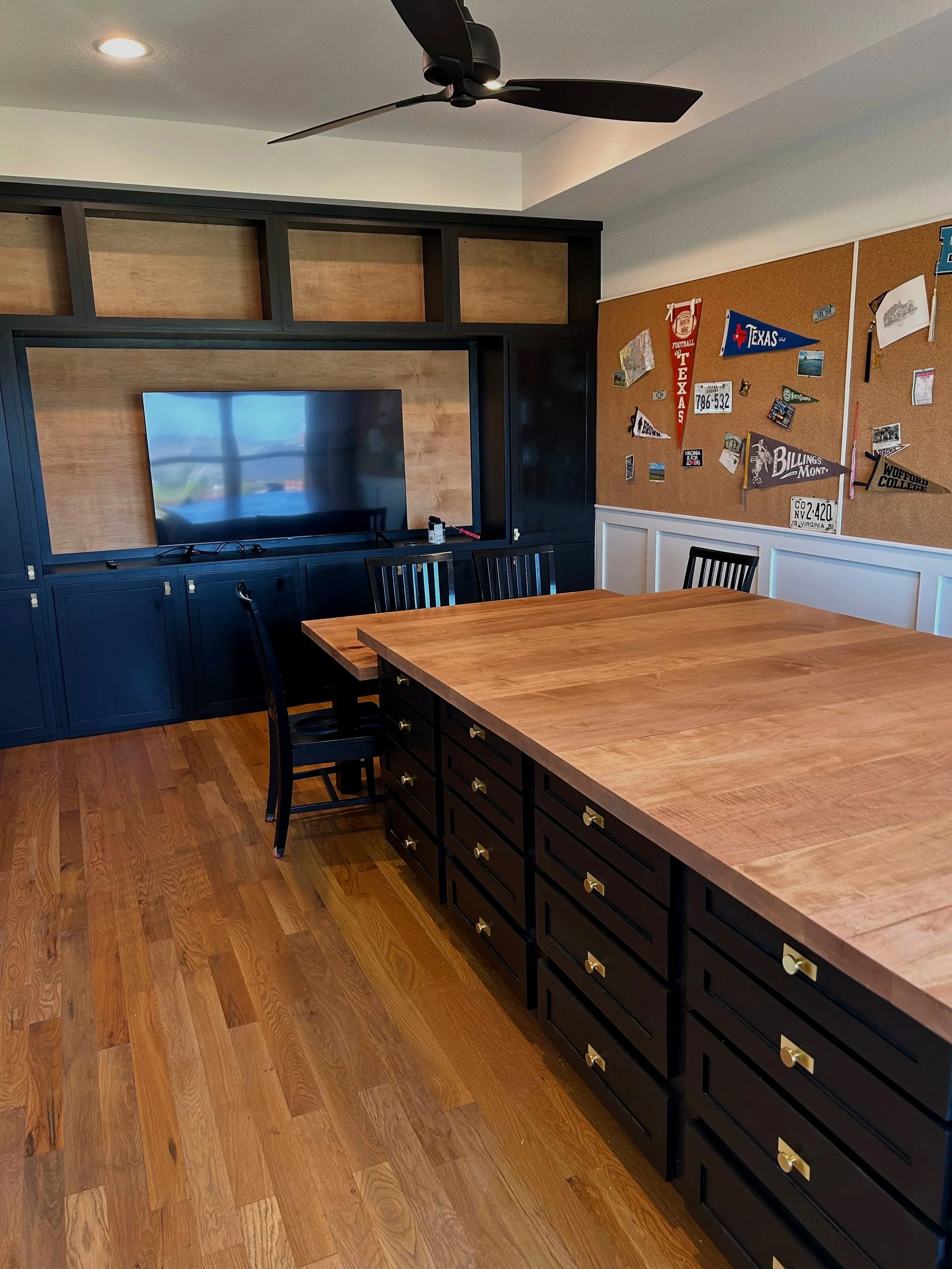 Custom craft room with a built in entertainment center. custom sewing maching storage and a matching craft island and table