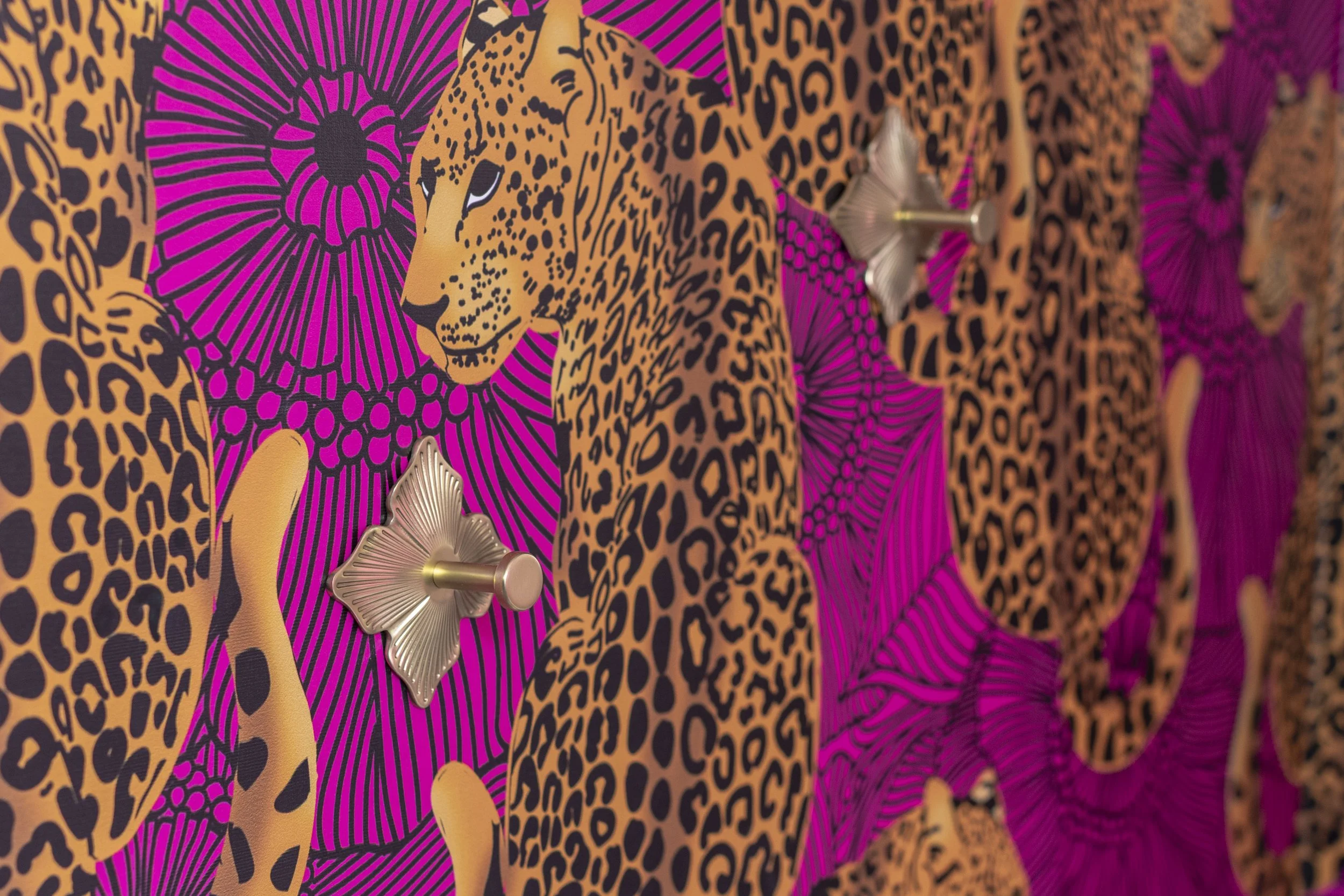 Brass flower hooks on pink leopard wallpaper