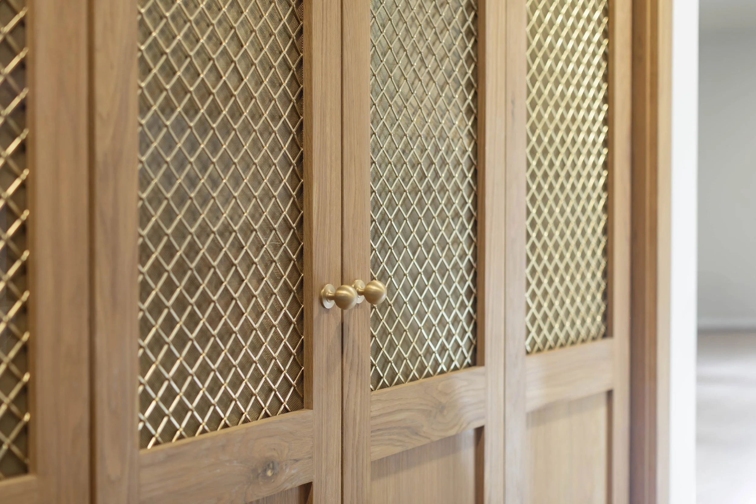 White oak pantry doors with brass mesh panels