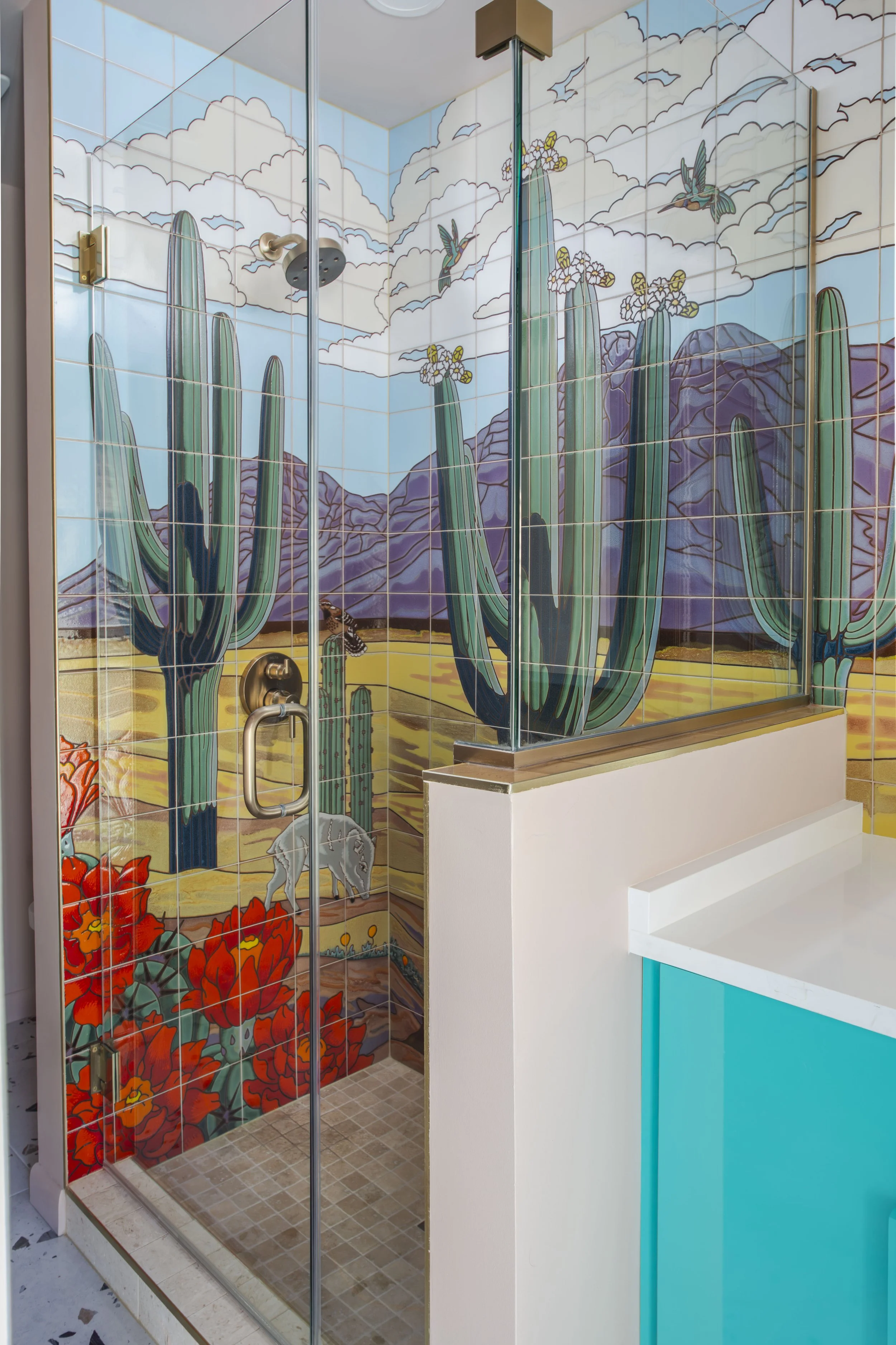 Shower with hand-painted saguaro cactus, mountains, and hummingbird tile mural