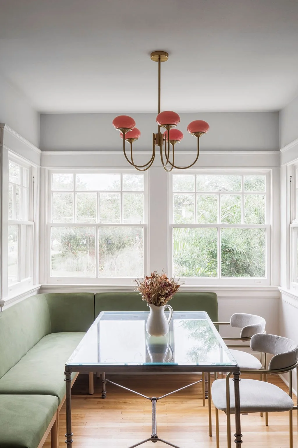 Breakfast banquette under a coral chandelier