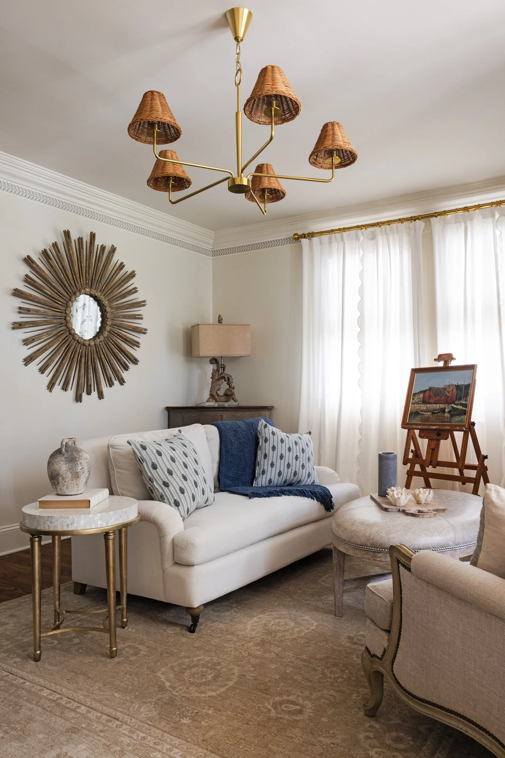 Living room corner with a gilded sunburst mirror and blue ticking pillows