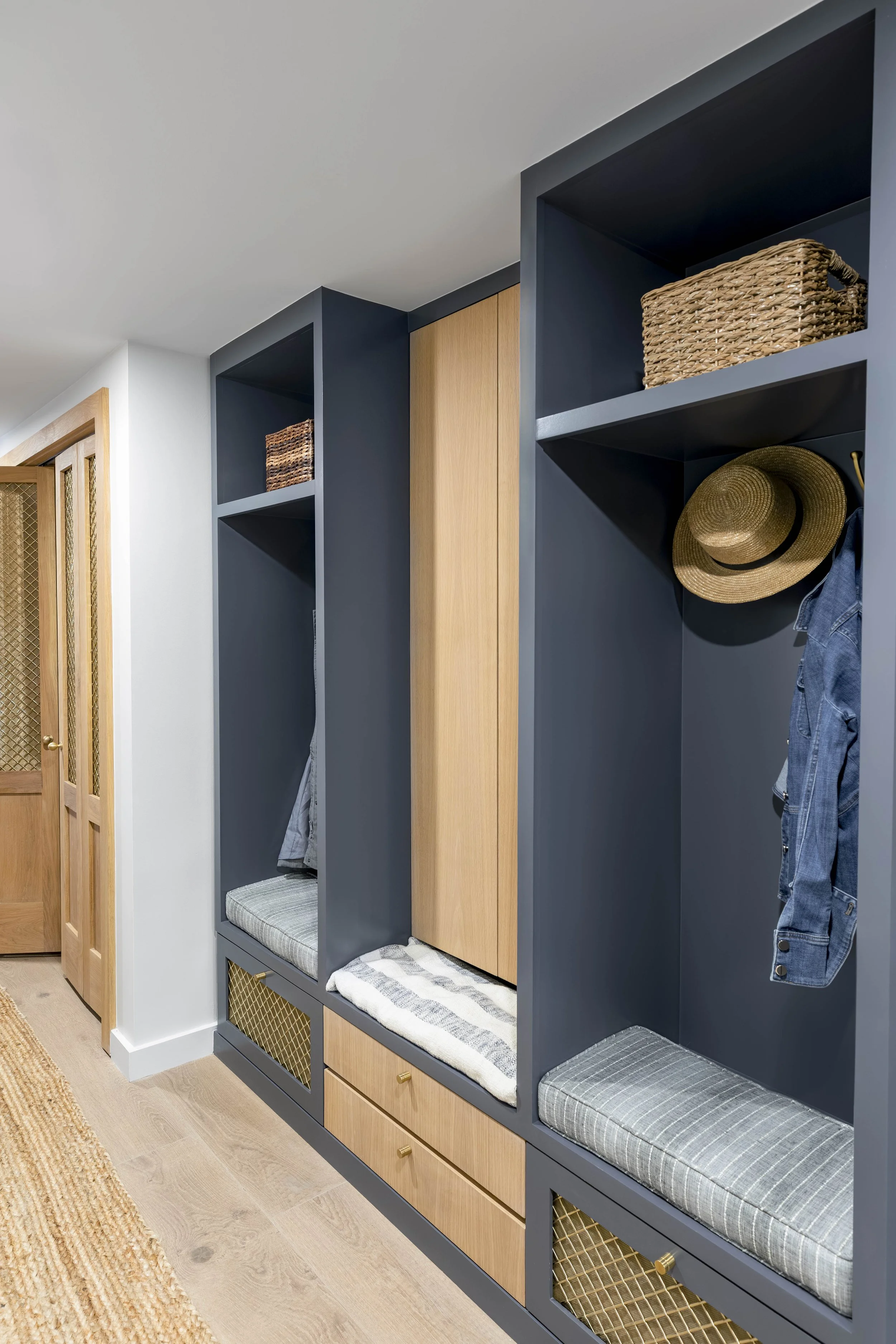 Navy mudroom lockers with bench cushions and brass mesh drawers