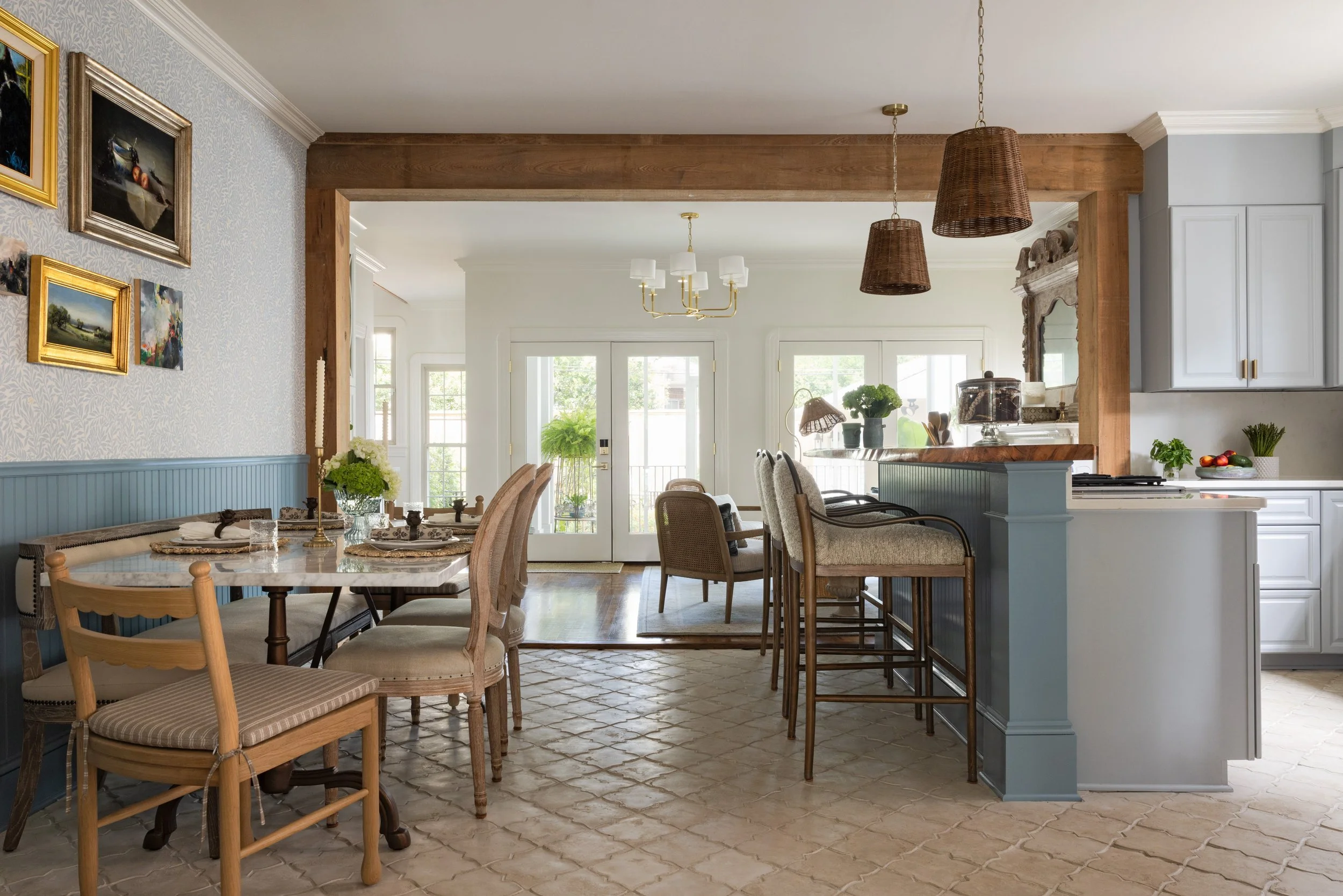 Open kitchen and dining area with a wood beam, blue beadboard, and French doors