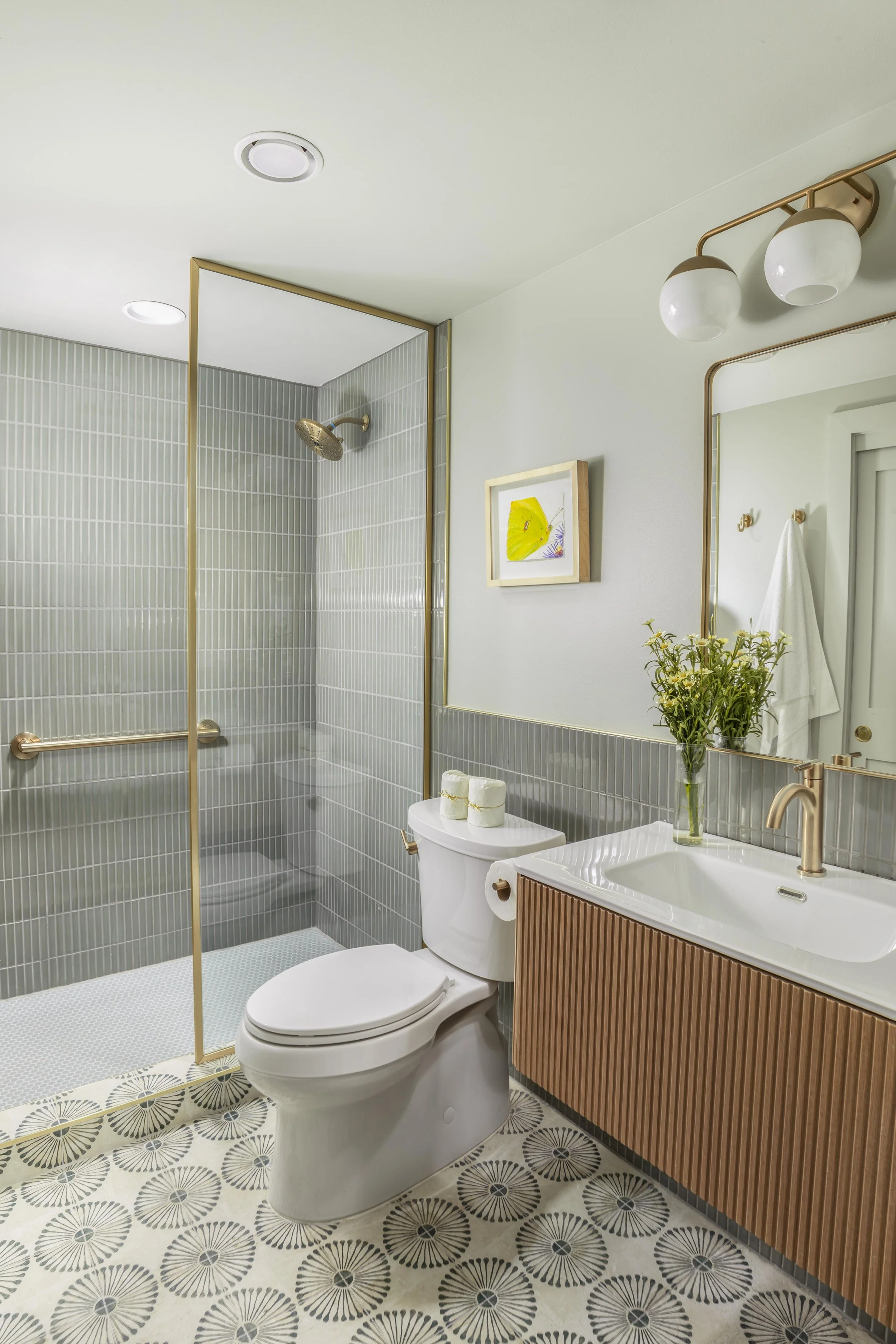 Wide sage green bathroom with grab bar and walk-in shower