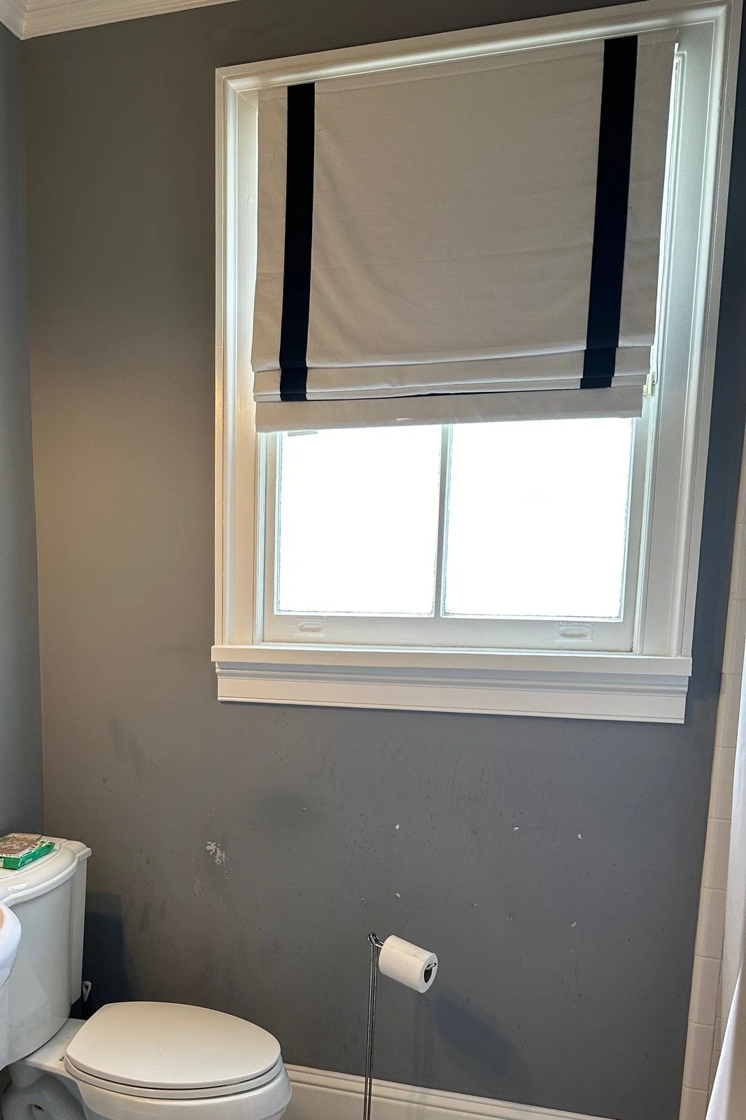 Before: the same window wall with gray paint and a basketweave tile floor