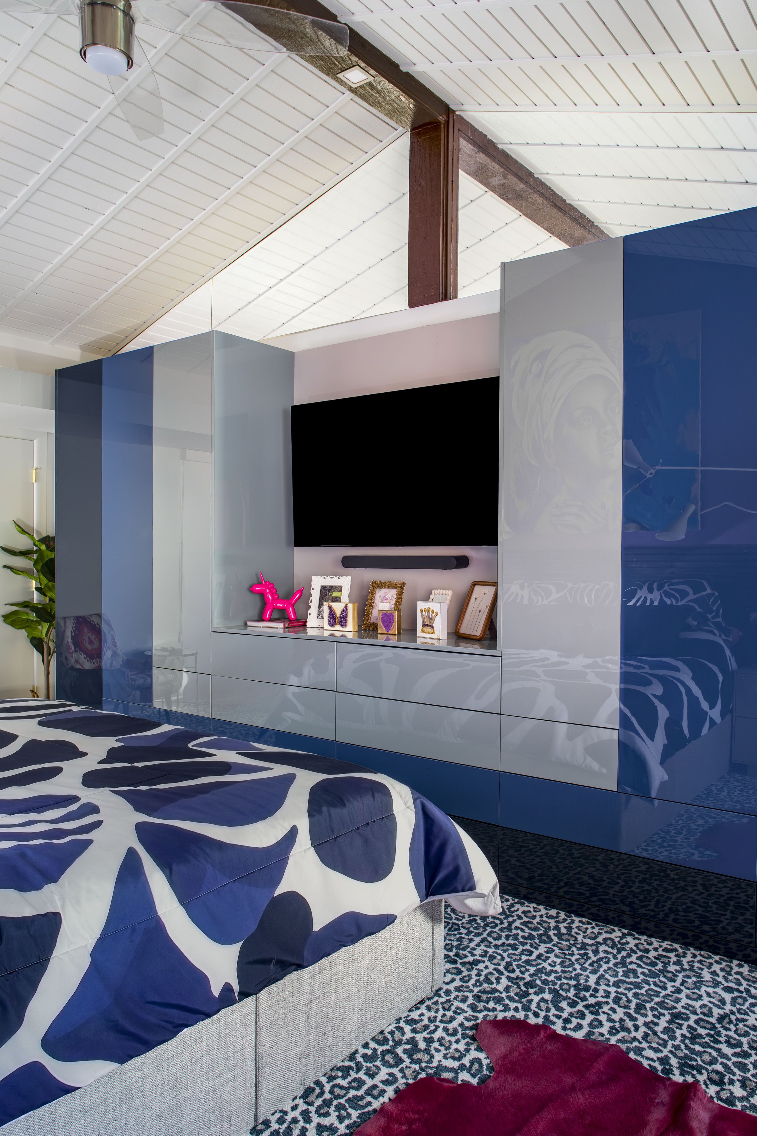 Custom high-gloss blue and gray closet wall with built-in TV niche
