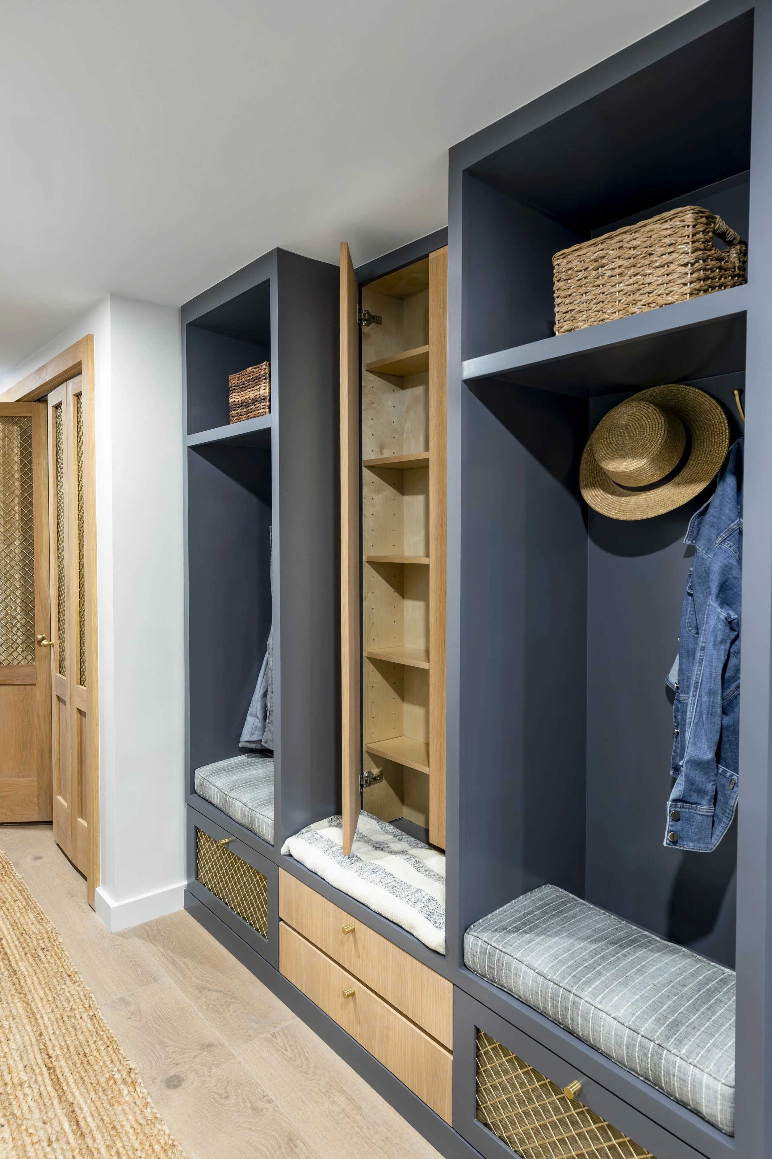 Navy mudroom built-ins with bench seating in New Orleans home by Val Spaces