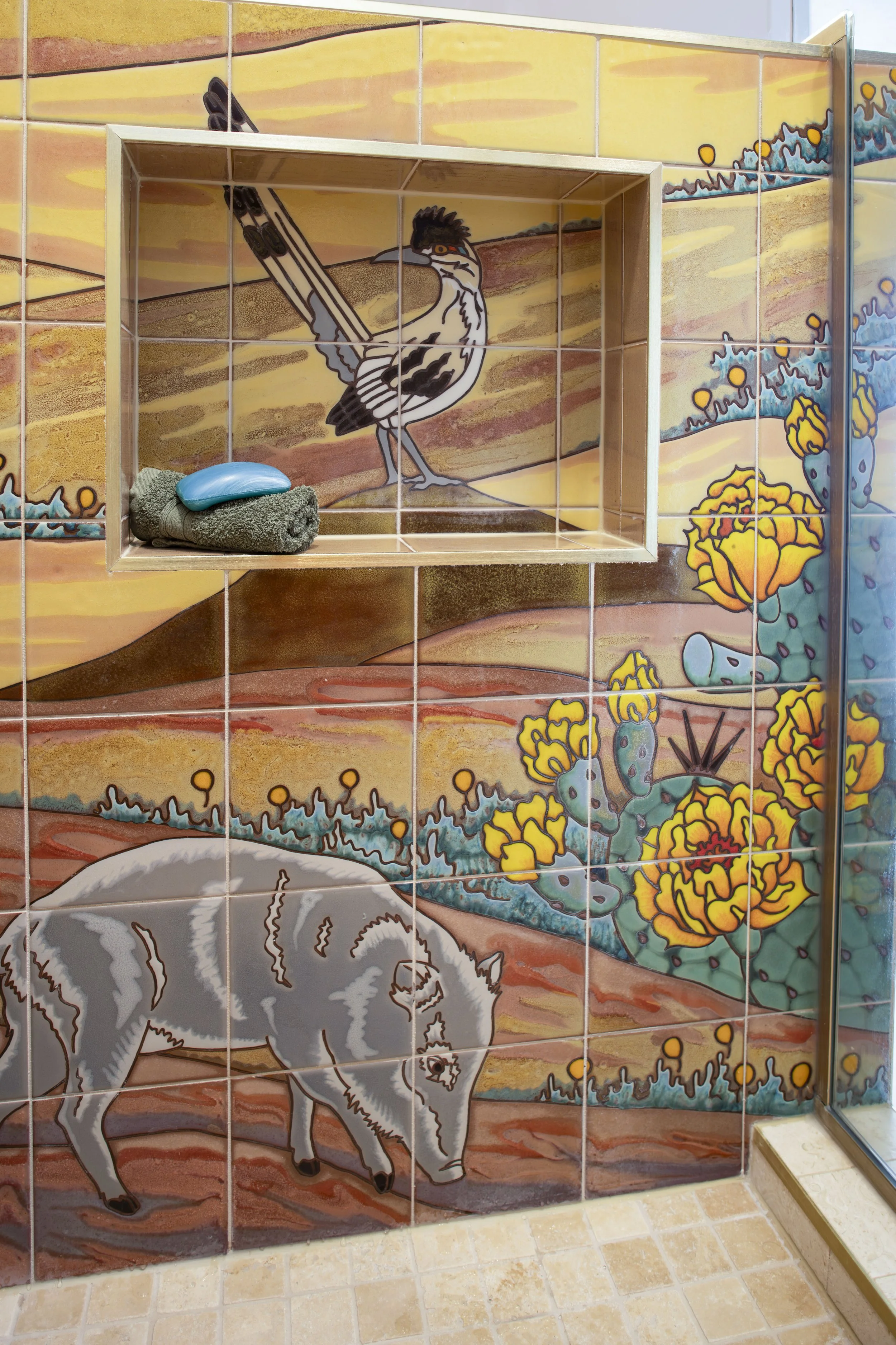 Shower niche framed around a roadrunner in a desert tile mural