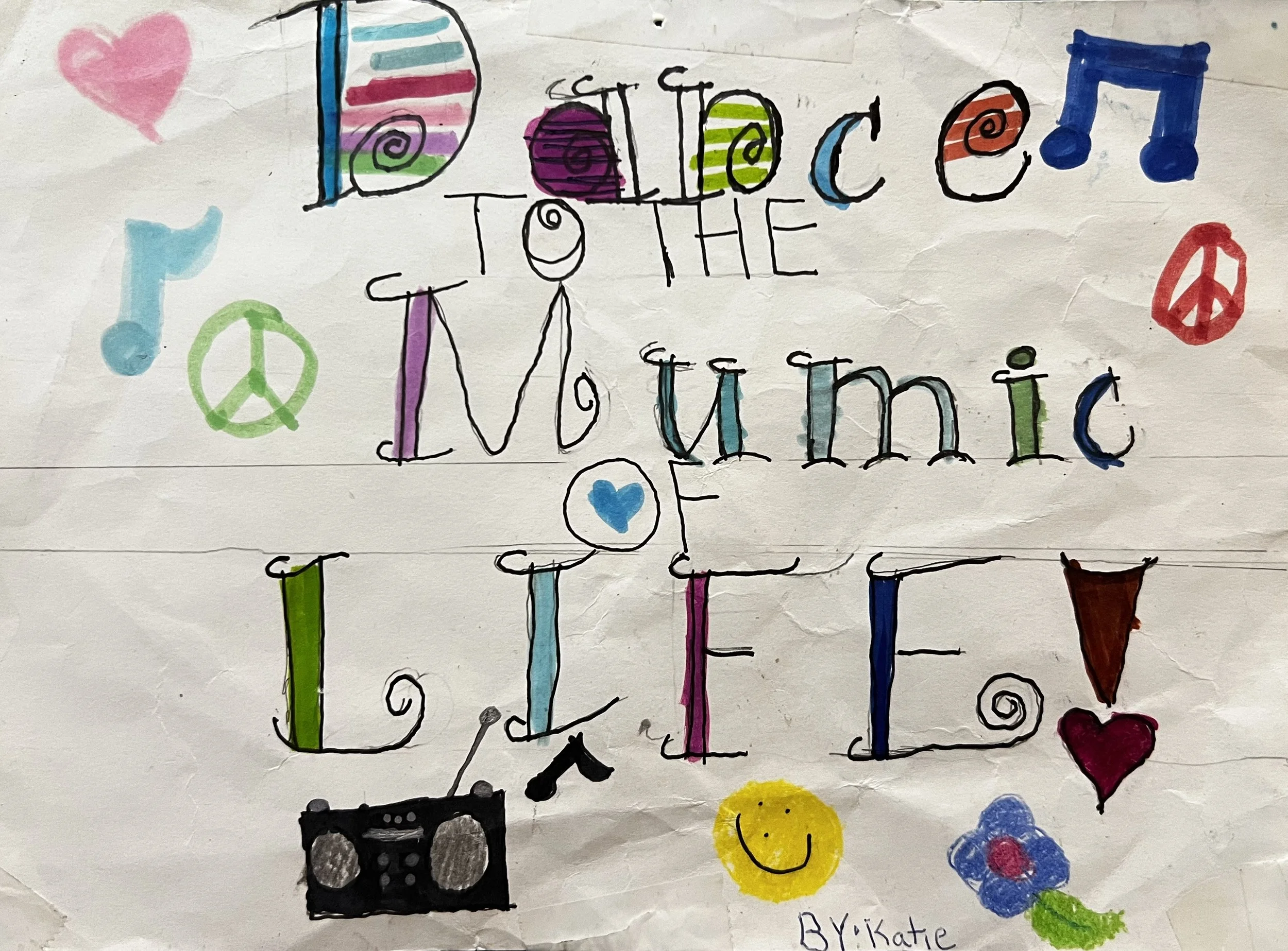 Fancy letters saying "Dance to the Mumic of Life" decorated with music notes, smileys hearts and peace signs