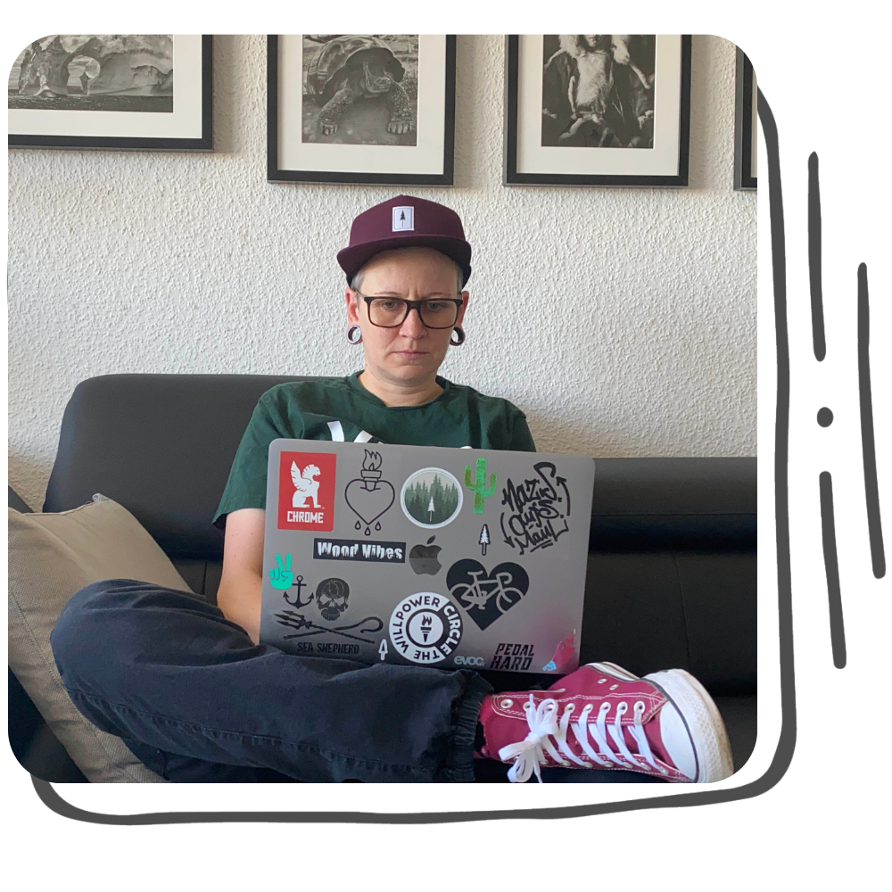 Andrea arbeitet konzentriert am Laptop auf dem Sofa und zeigt sich auf ihrer Portfolio-Seite im Arbeitsalltag als Texterin.