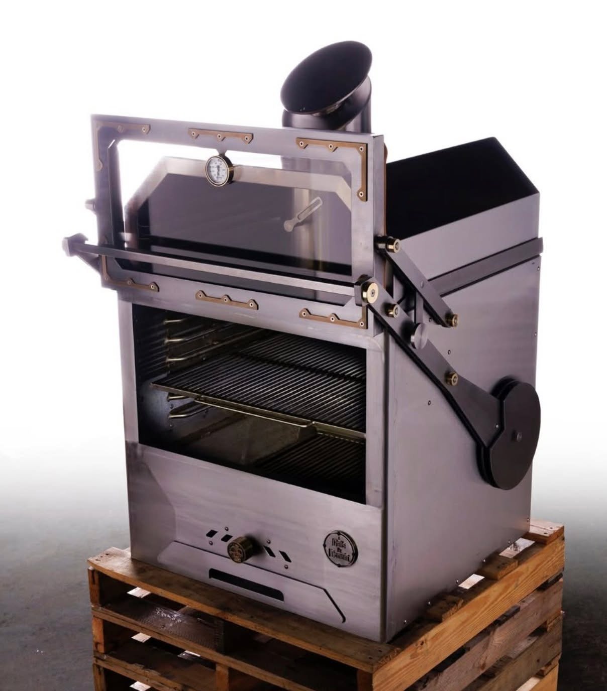 Fueled by wood or charcoal, our solid-fuel oven delivers precision and power with timeless simplicity.
A weighted vertical door moves smoothly up and down, never in the way.
An ash drawer below keeps things clean, while the resting area above holds p