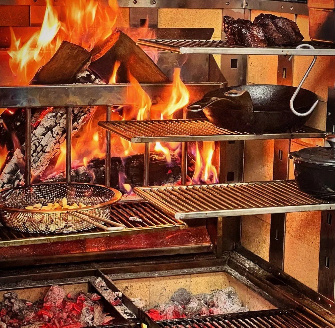 This is what full control looks like.

Multiple levels of heat. Live flame for searing. Deep coals for slow work. Tools sitting exactly where the chef needs it.

The best fire cooks aren't reckless, they're precise. 
And control only comes when your 