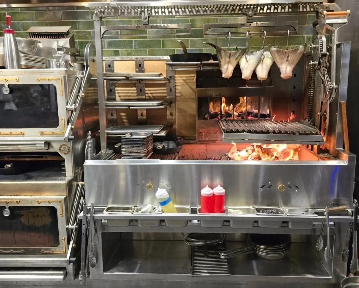 The chef who runs this station thinks in fire.
@snakerivergrill  needed a workstation that could keep up,  multi-zone heat, proteins hanging where they want them, fish collars drying right above the embers, a chain hoist to manage load over the coals