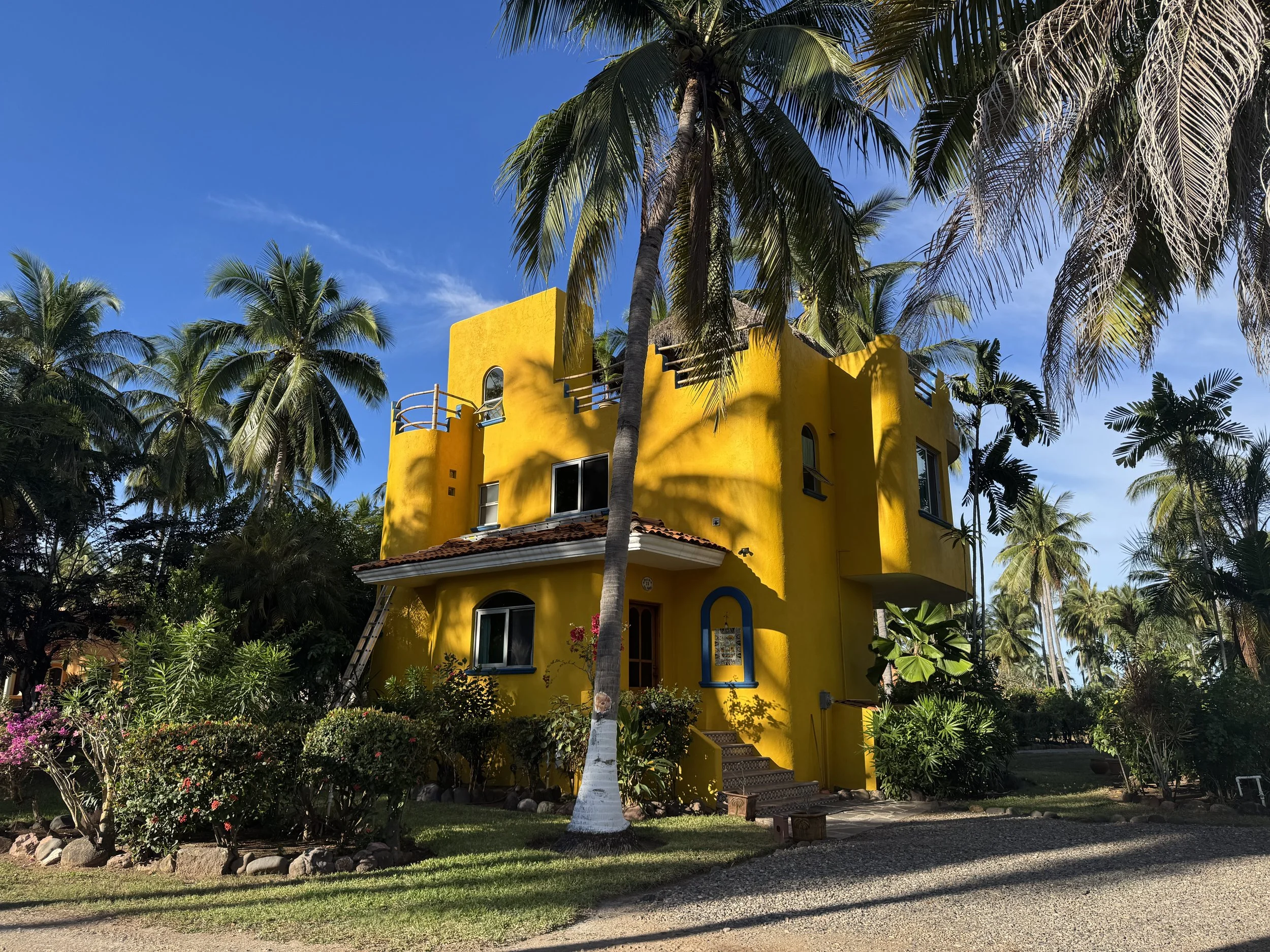 Yellow house with gardens in front