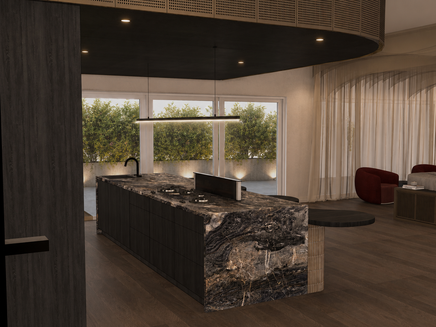Modern kitchen with marble island, black faucet, gas stove, large windows, sheer curtains, and adjacent seating area with red chairs.