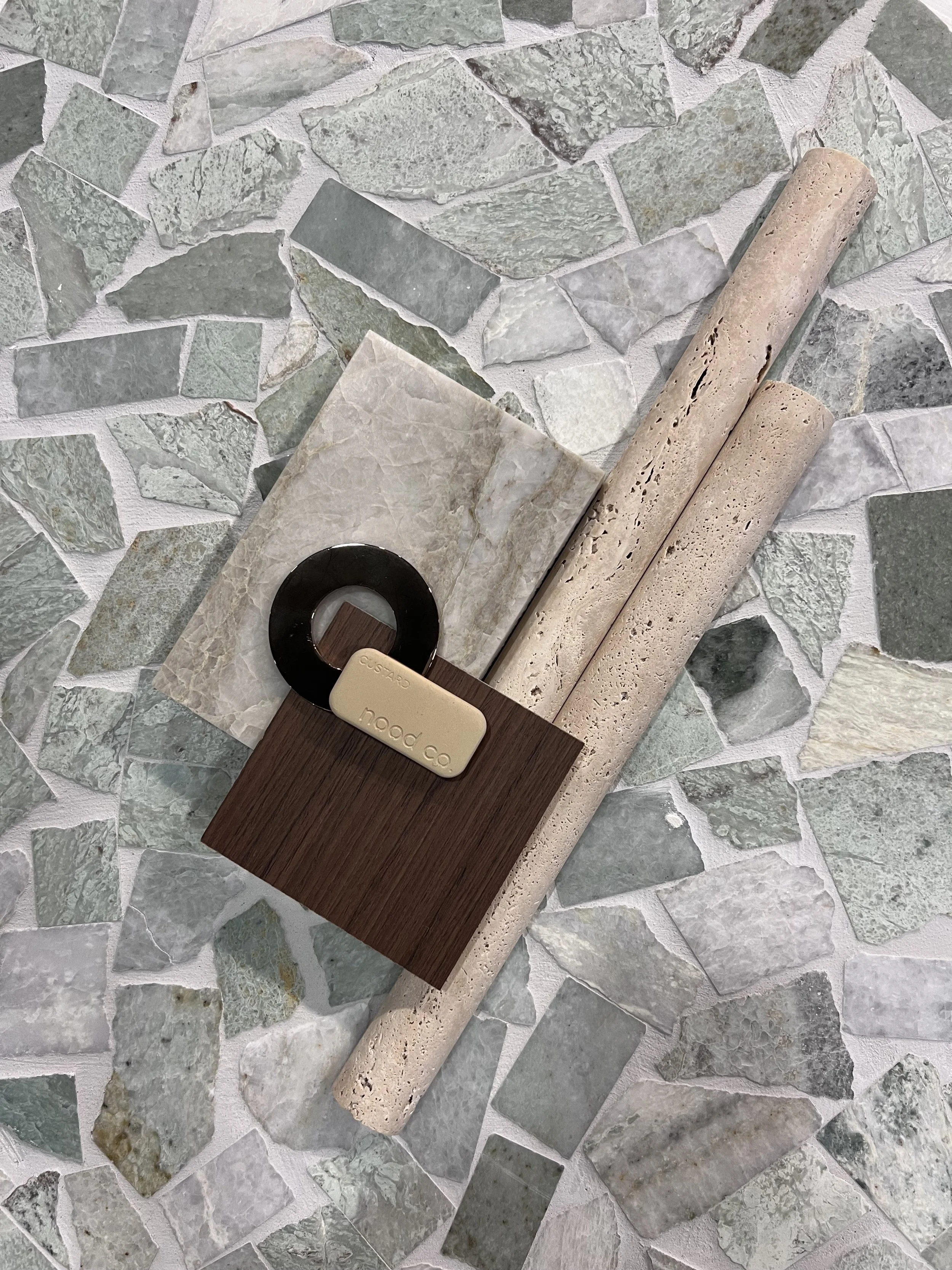 Flat lays for a bathroom design using tiles, walnut timber, brass fixtures, natural stone and concrete basin.