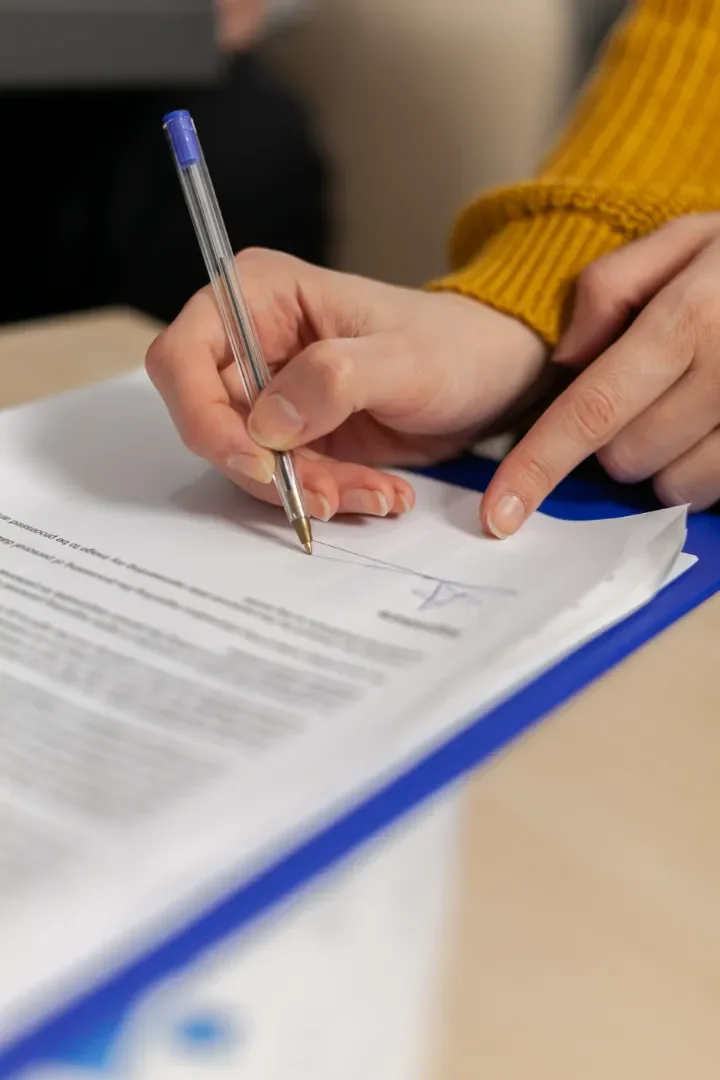Woman signing grant profile paper in office