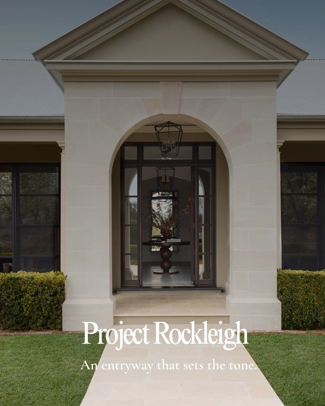 A deliberate sense of arrival unfolds through this entryway. A beautifully proportioned stone archway frames the approach, while substantial timber doors lead into a foyer where scale meets intimacy.

Underfoot, spectacular Italian stone tiles, exclu