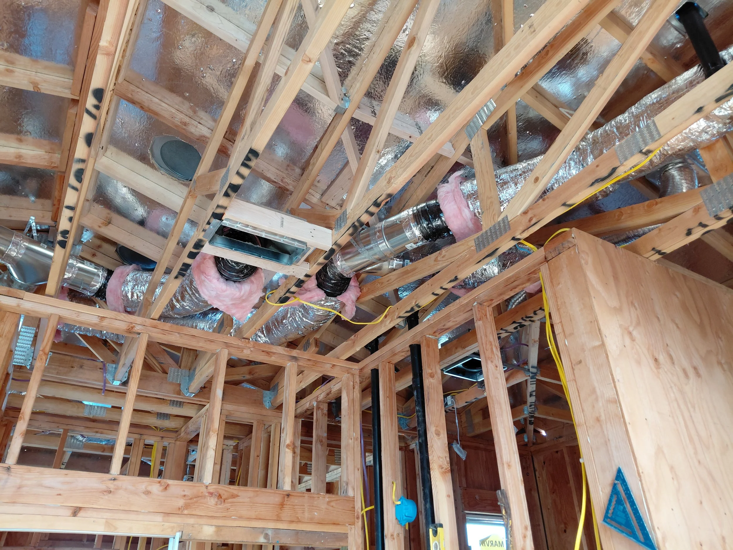 Consultant reviewing architectural plans for an Accessory Dwelling Unit with homeowners, displaying detailed models and blueprints.