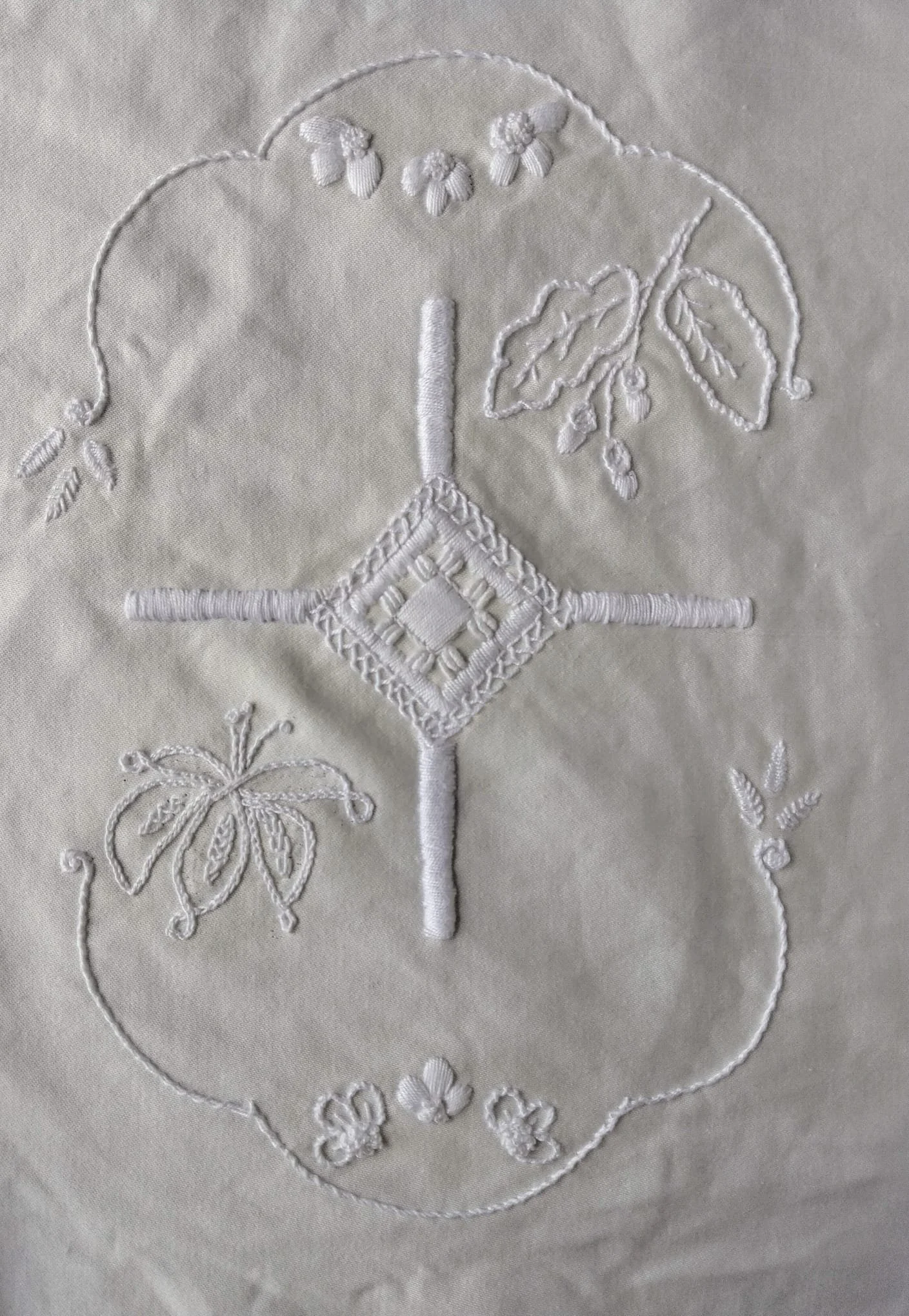 White embroiidered cloth with the ulster St Brigids cross, similar to a gods eye design