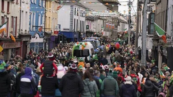 Photo from last years parade , lots of people dresses up and a flaot decked out in green white and gold.