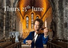 Poster with the inside of St brigids Cathedral lit up ambre with  Vladimir Jablokov wearing a blue velvet jacket playing violin