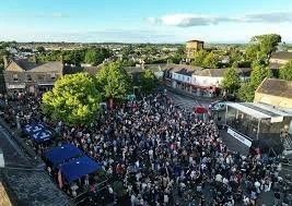 Aerial photo of last years session on the square for the end of the festival, the square is packed with people , big stage , and many awnings