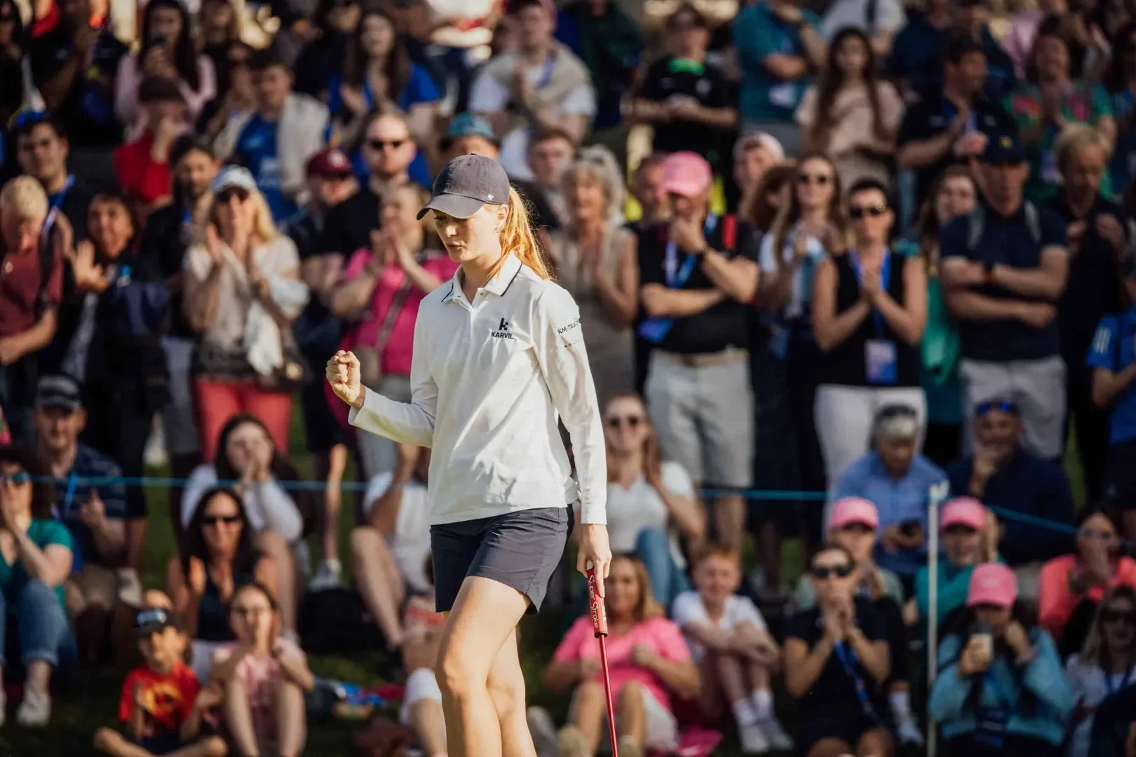 Female Golfer Pictured, with audience behind in stands