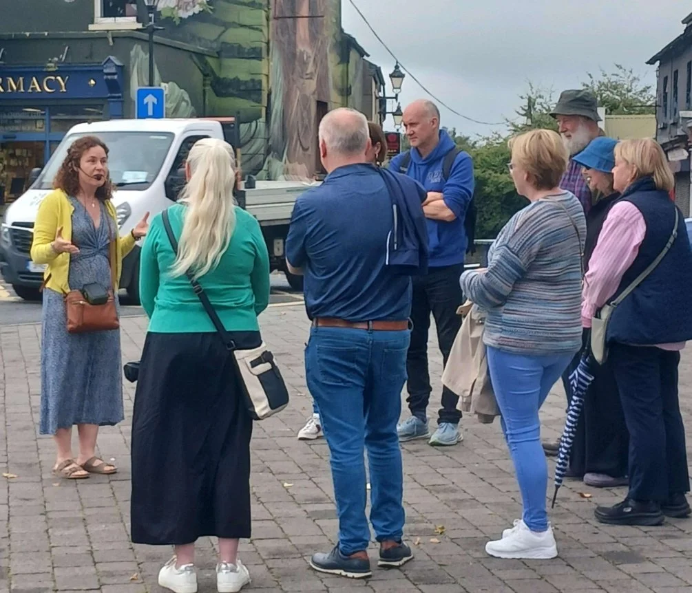 group of men and women gathered round in market square kilddare town as they begin their gided walk through and around the town visiting the manastic sites