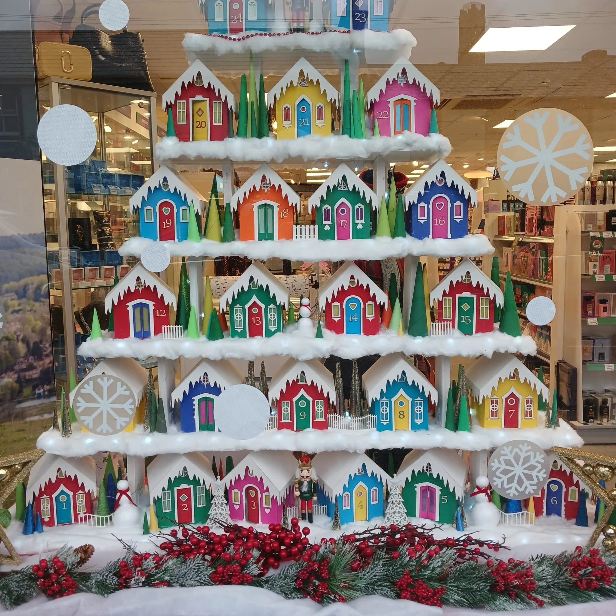Photo of a shopfront with 25 colourful christmas decorated hunts complete with trees and snow.