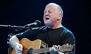 Photograph of Christy Moore singing and playing guitar