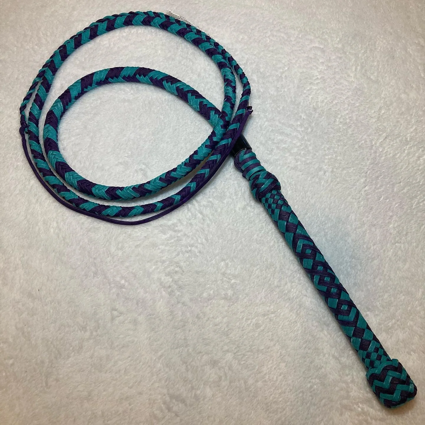 A braided blue and purple lanyard with a loop and a small strap at the end.