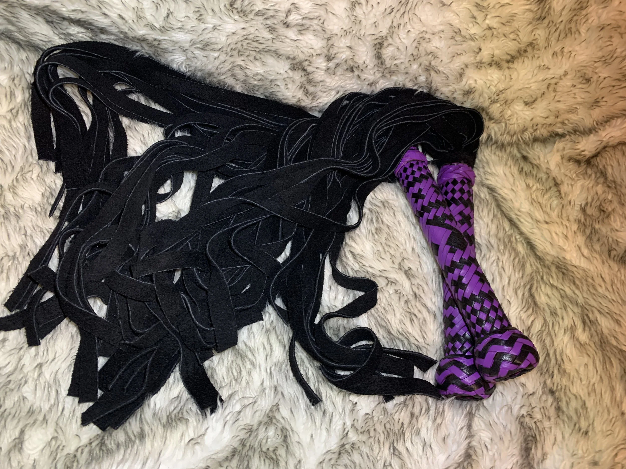 Twin 3' suede floggers with custom braided handles in black and purple kangaroo leather.
