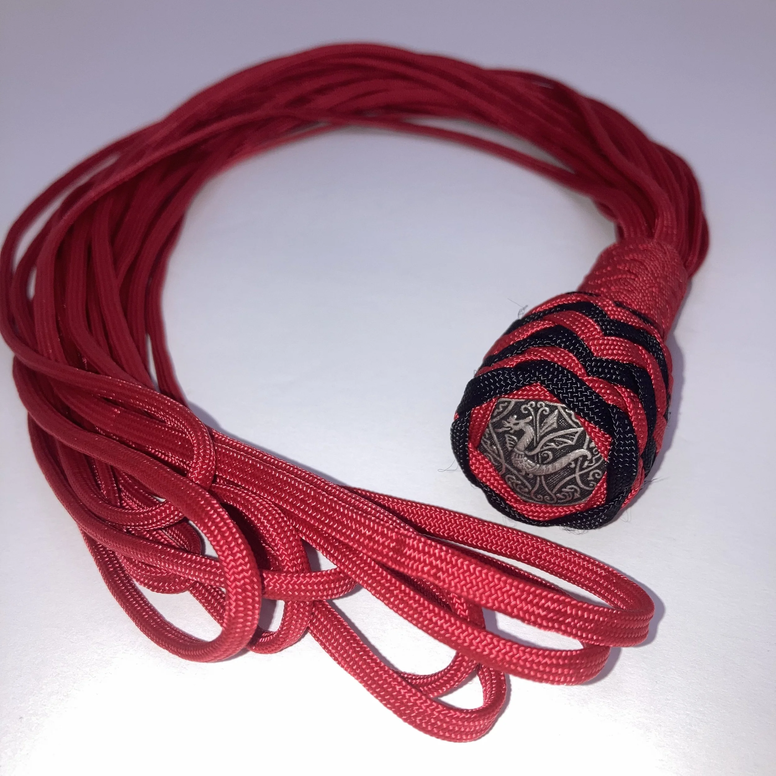 Red and black woven lanyard with a metal emblem featuring a dragon design.