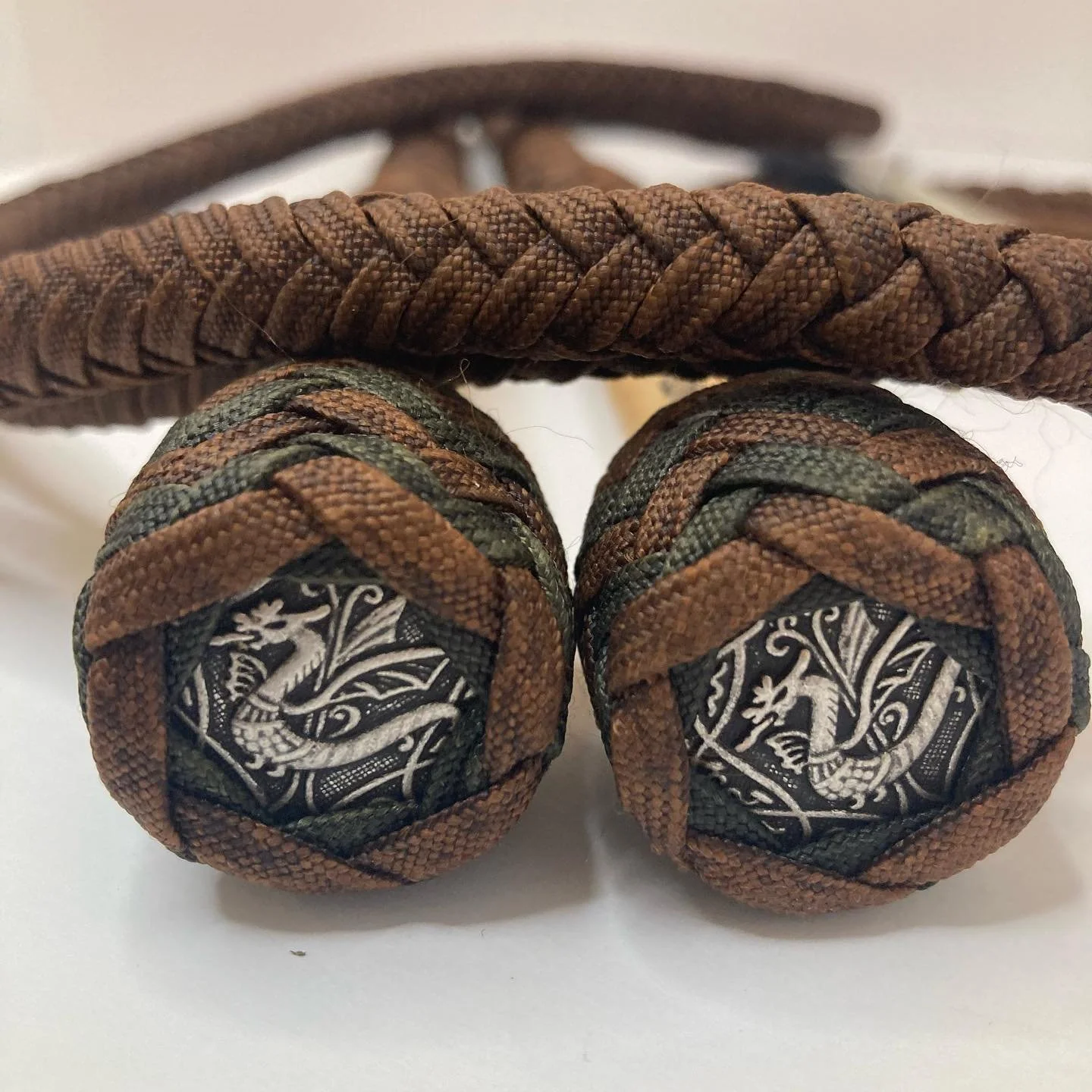Close-up of brown and black laced shoe soles with a dragon illustration on the heel