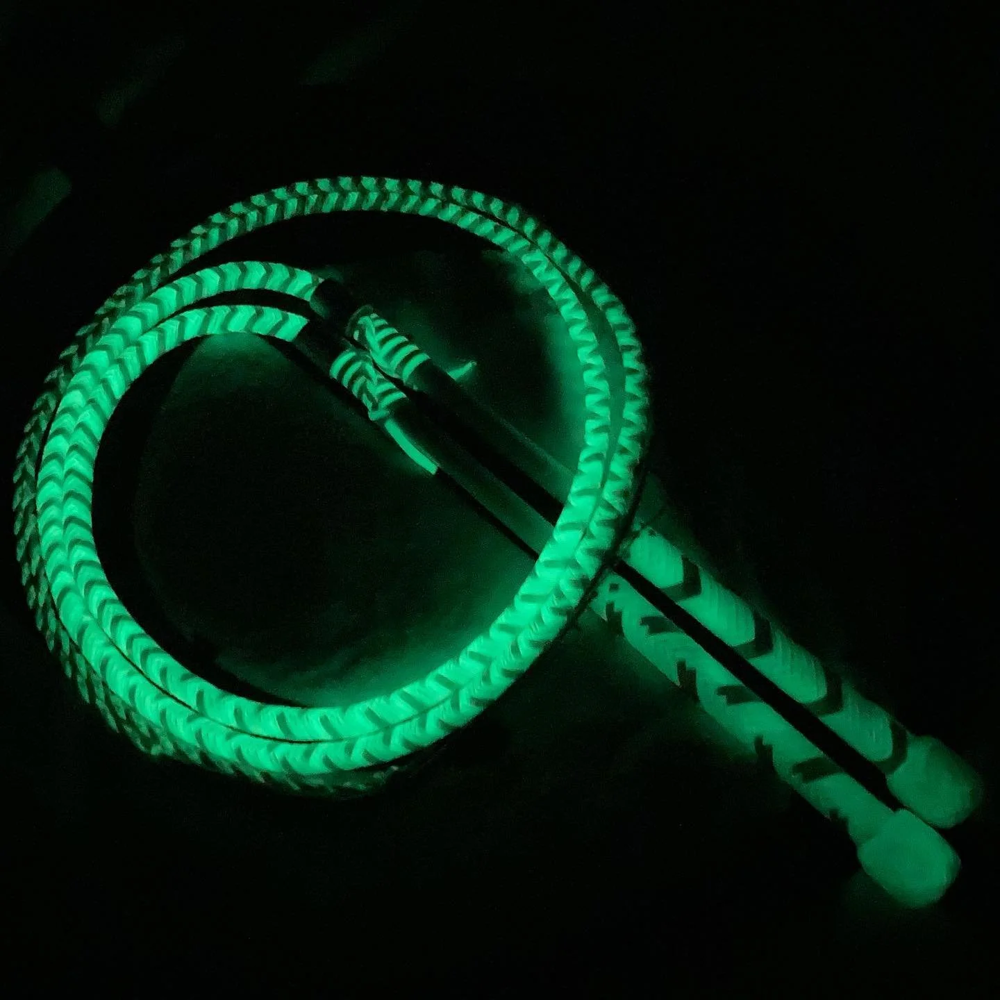 A coiled green glow-in-the-dark cable with connectors at both ends.