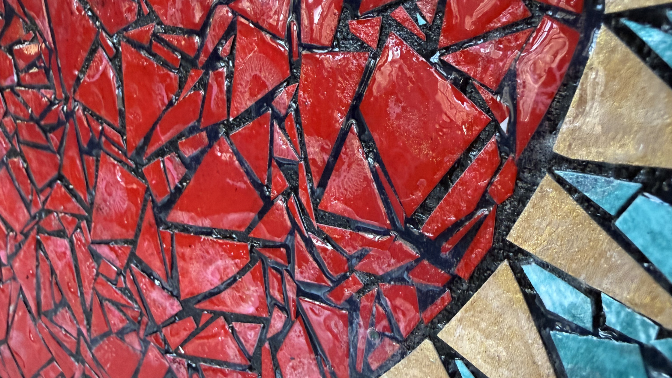 Close-up detail of dimensional Mod Podge glaze on red paper mosaic tiles showing ceramic-like glossy finish with turquoise and gold tiles