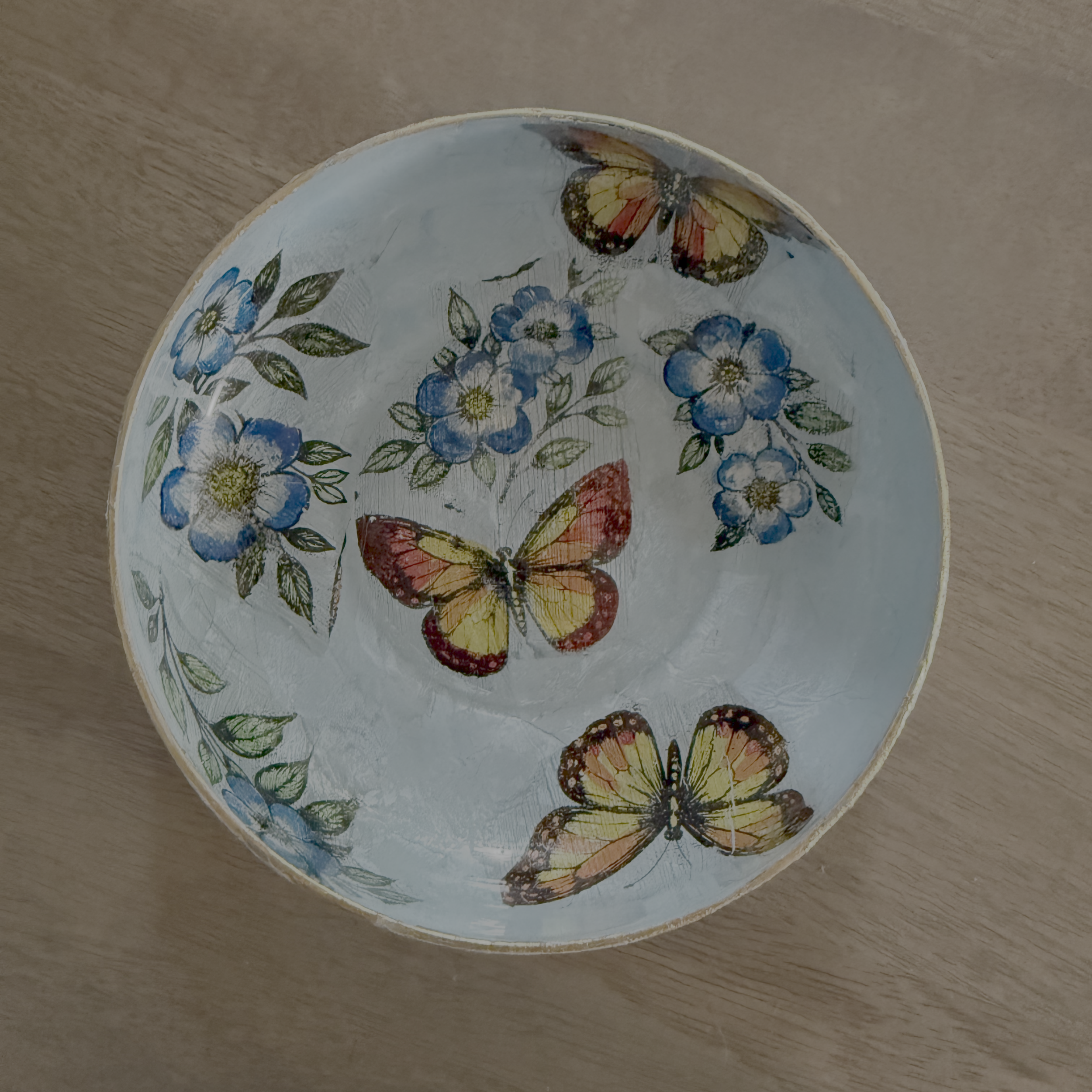 Finished decoupage bowl with hand-painted blue florals and butterflies made from gelli-printed wet-strength tissue paper