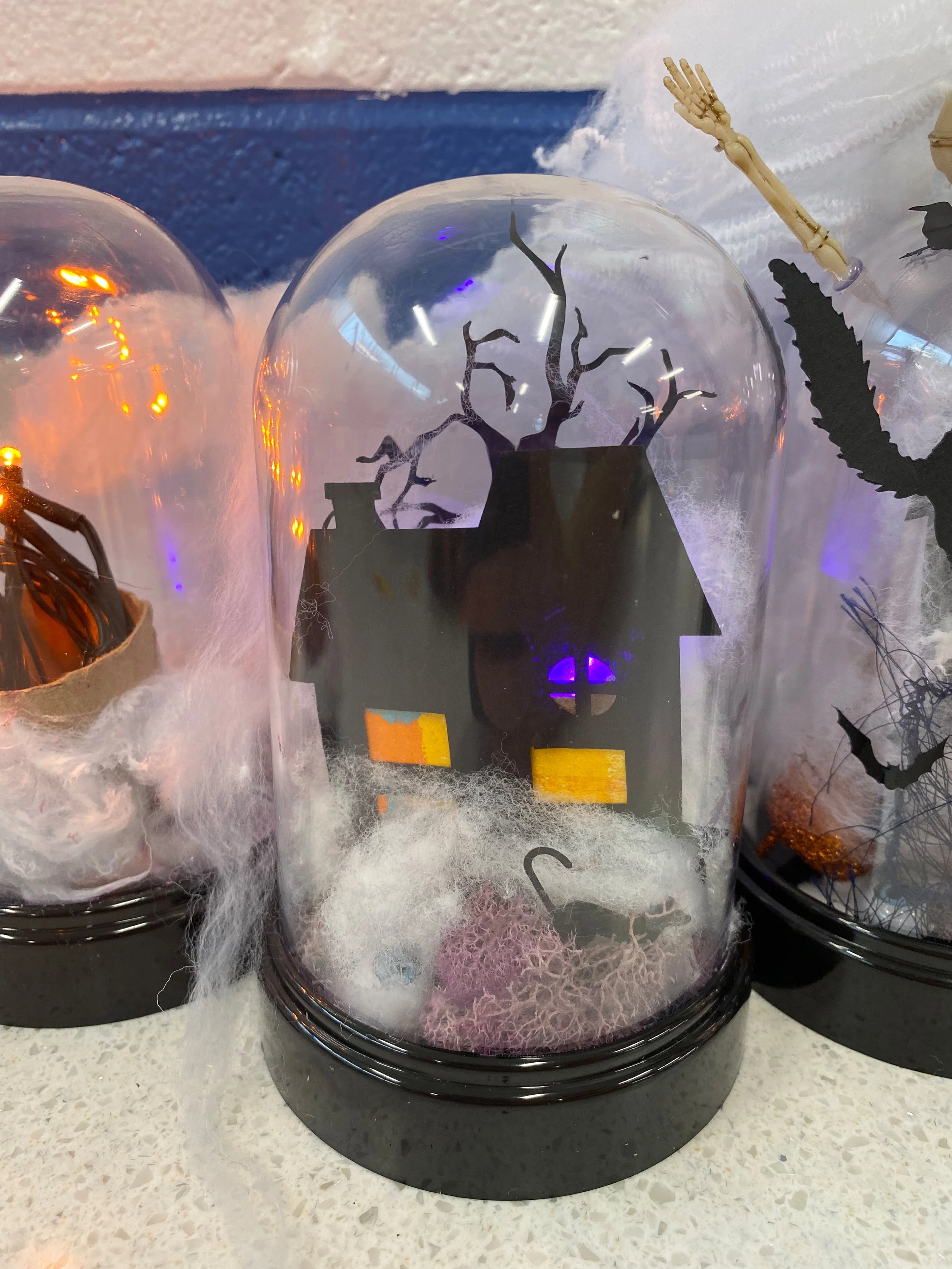 Miniature haunted house Halloween cloche with glowing windows, spooky tree, moss, and faux spider webs