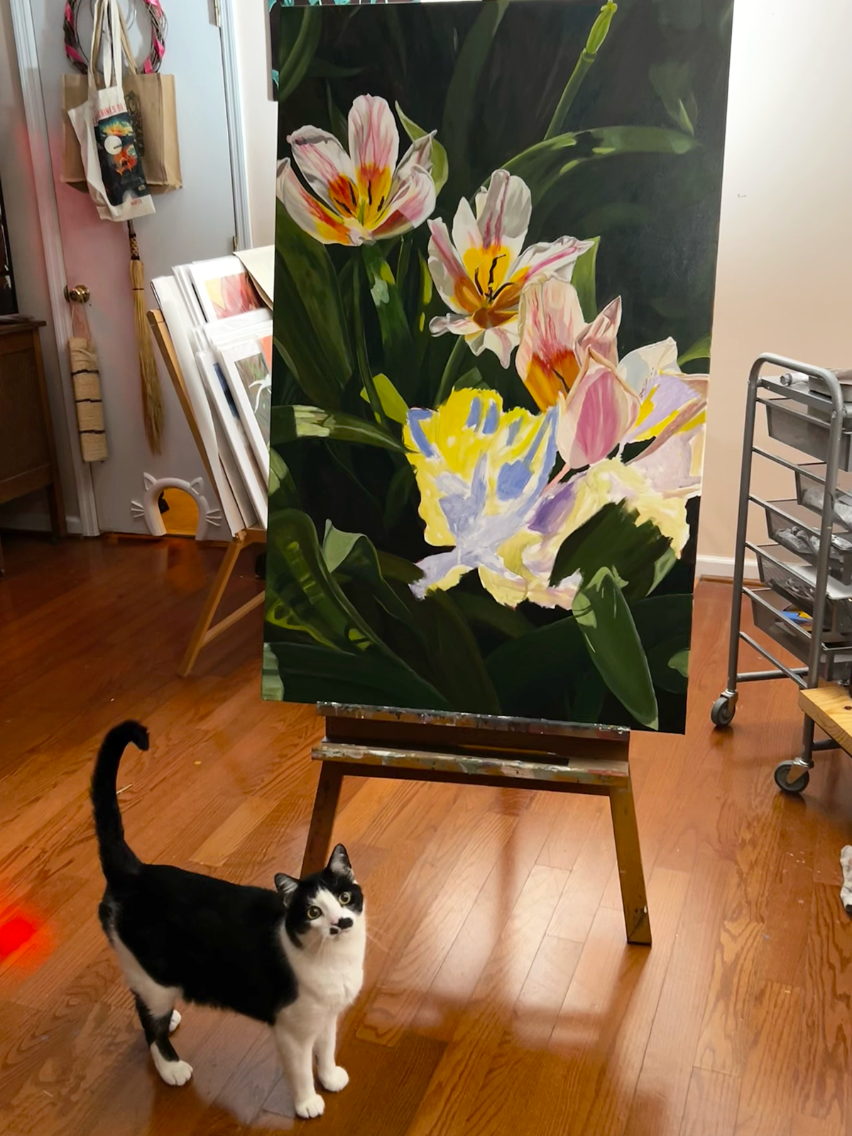 backed by lush greenery. A little black-and-white cat stands before the piece as if it were his very own.