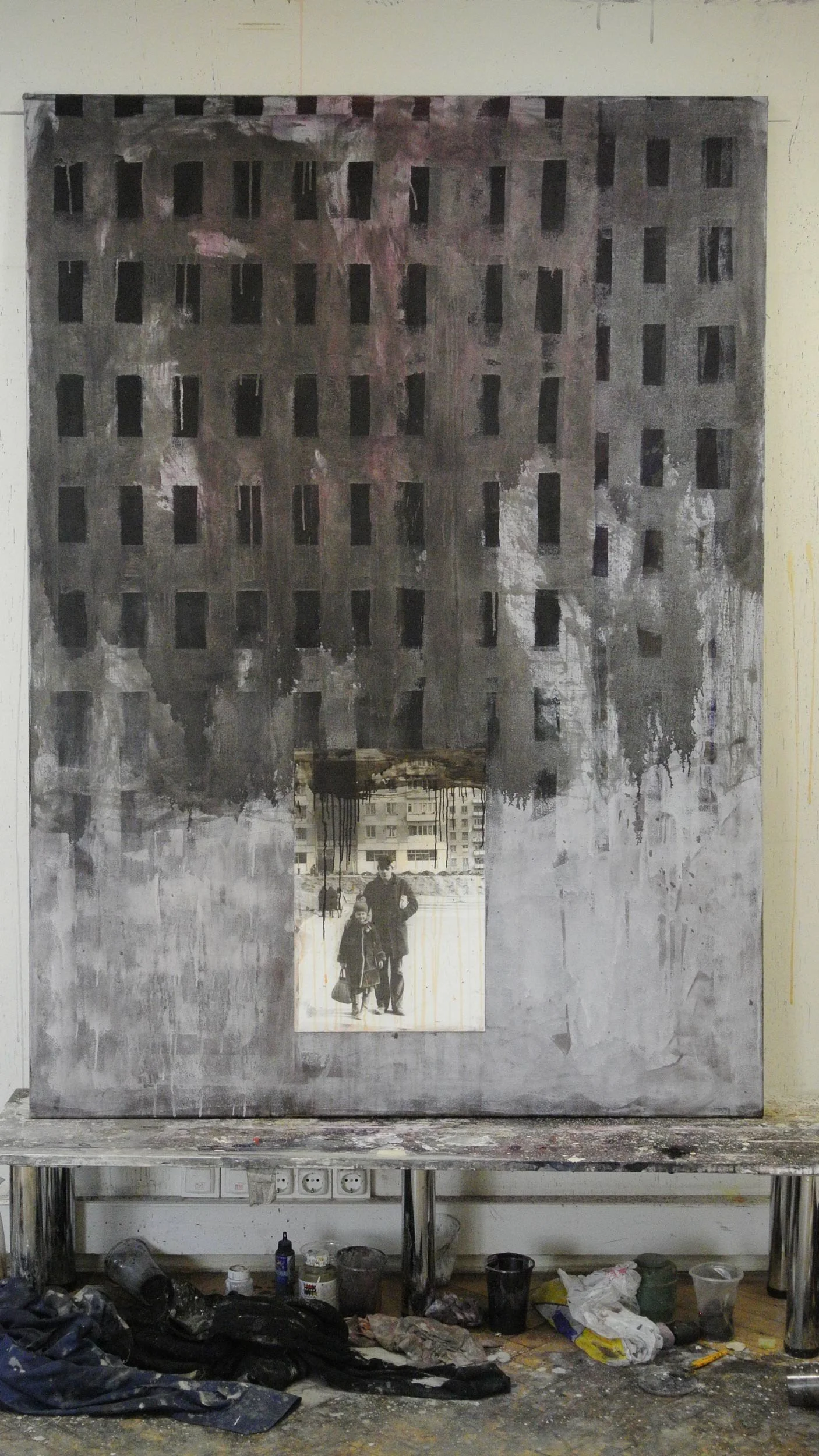 A painting from the series Suburb by Vakho Bugadze (ვახო ბუღაძე, Vakhtang Bugadze) stands against the wall in his studio.