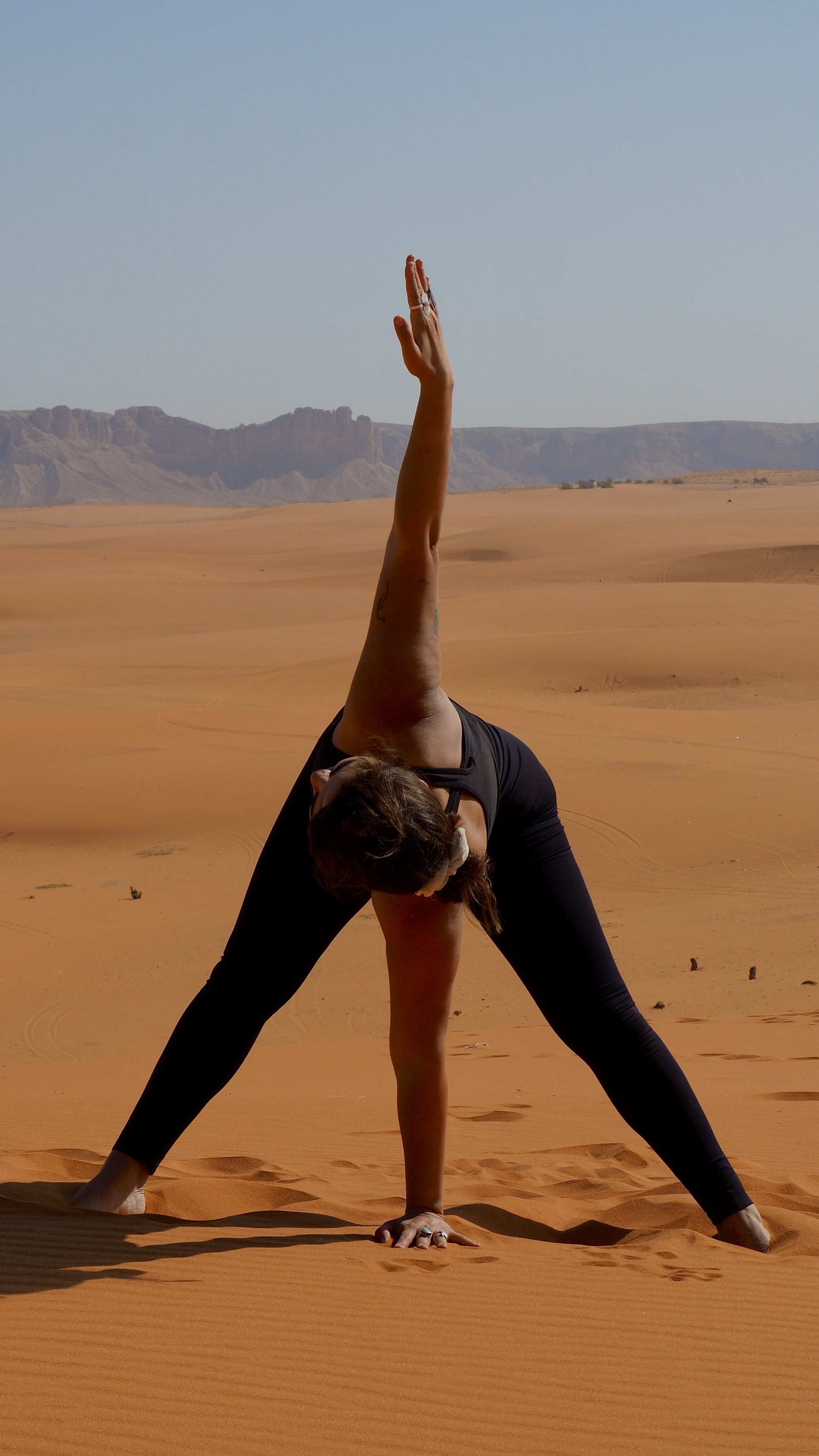 Person performing yoga pose in desert landscape
